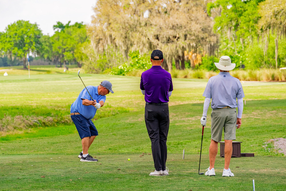 An Instant Golf Improvement coach with a golfer on the course at ChampionsGate